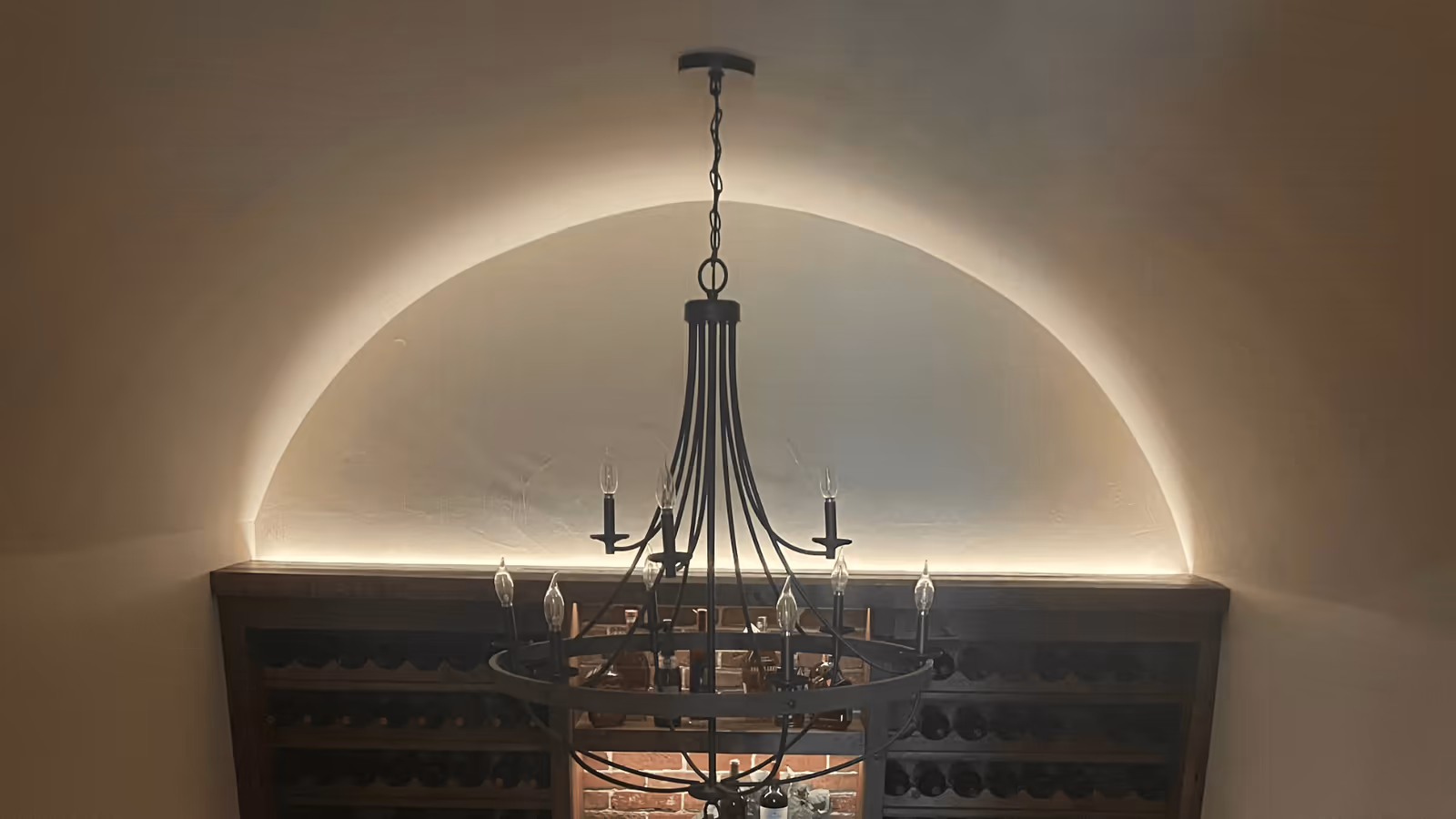 Chandelier and arched accent lighting in a finished room