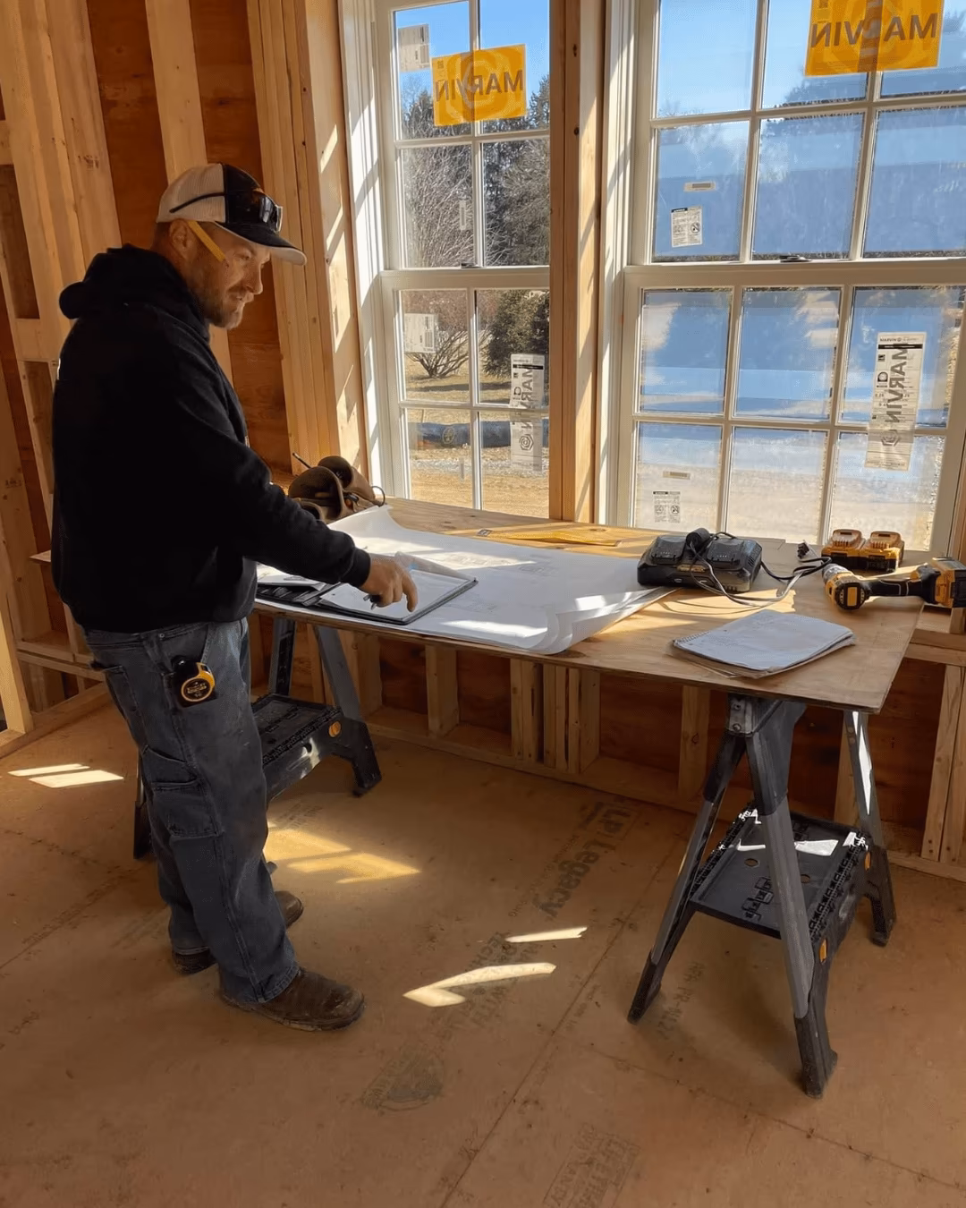 Yorktowne technician reviewing plans on a work table inside a framed room