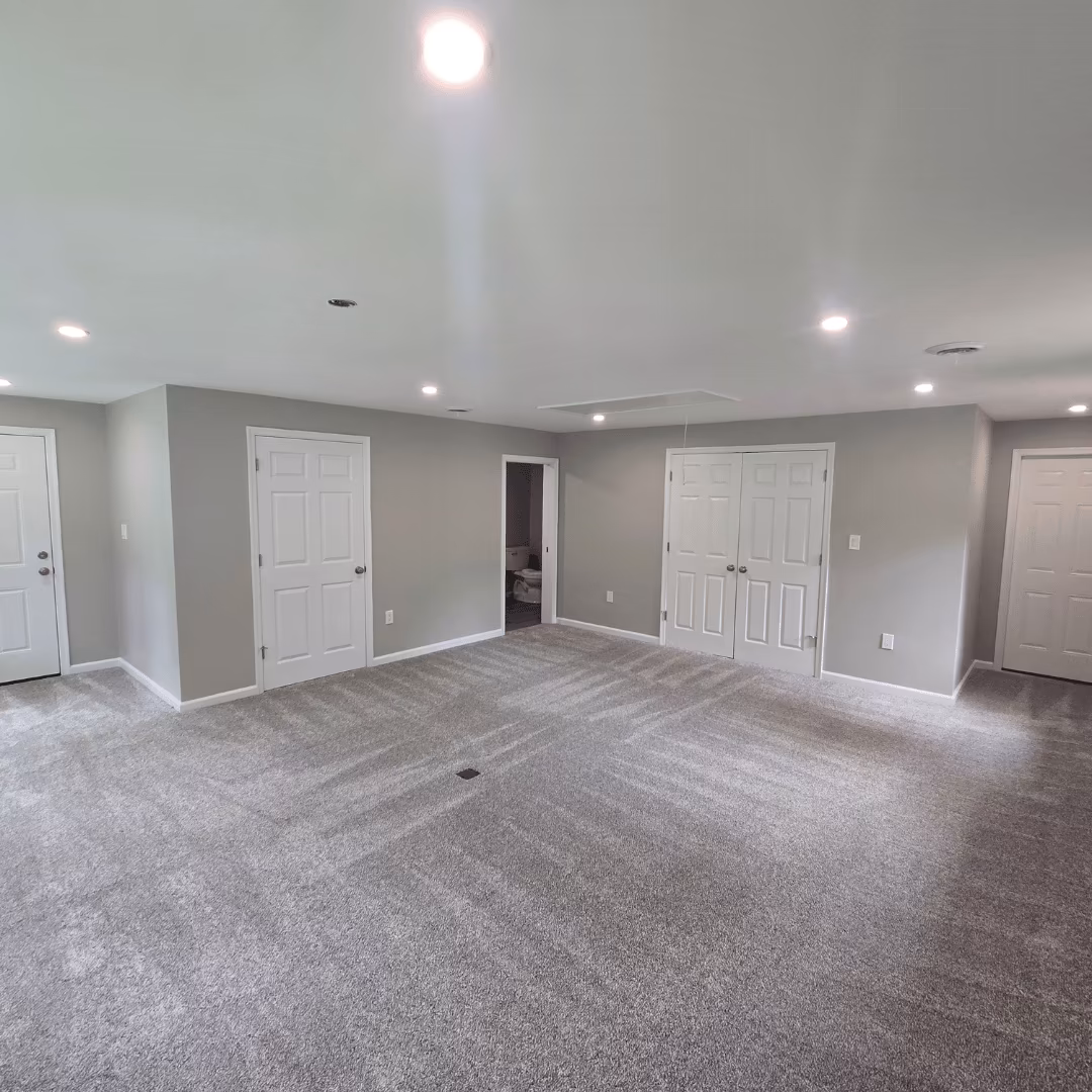 Finished basement with carpet, recessed lights, and white doors