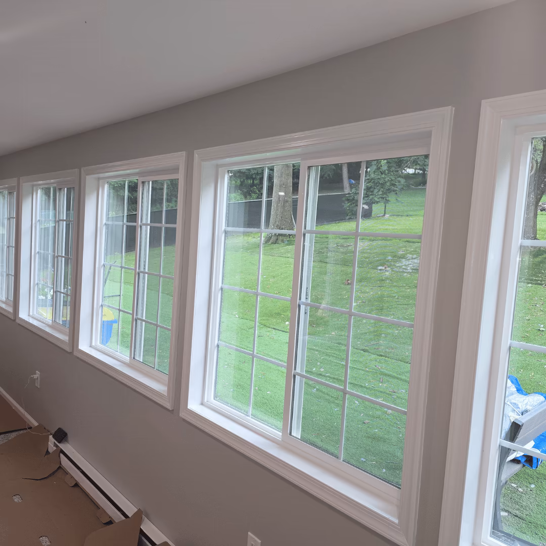 A row of new white-trimmed windows looking onto a yard