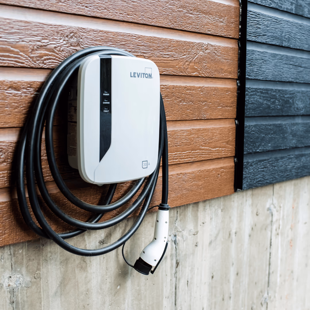 Wall-mounted home EV charger with the cord coiled beside it