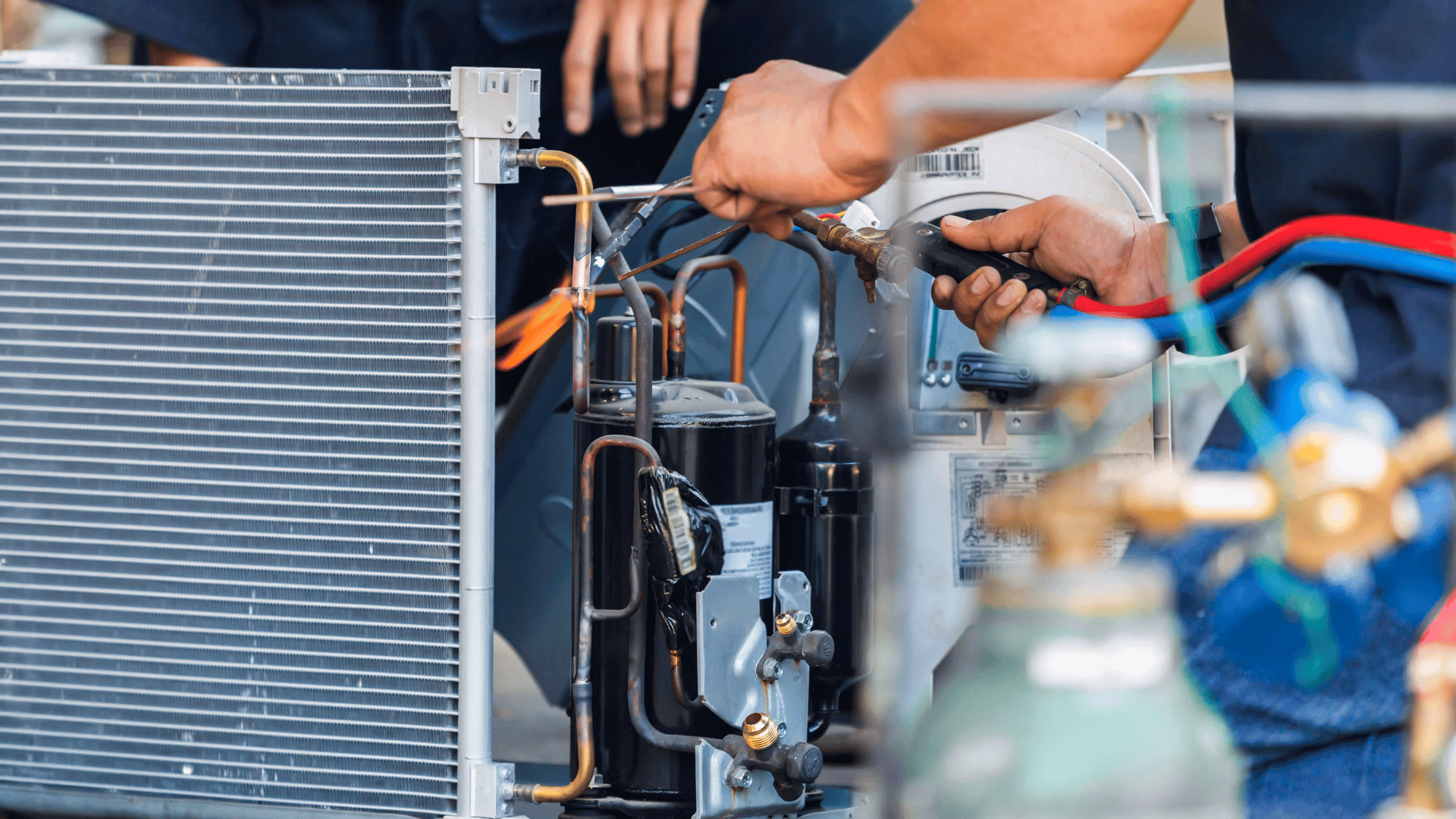 Technician connecting gauges to an air conditioner during a service call