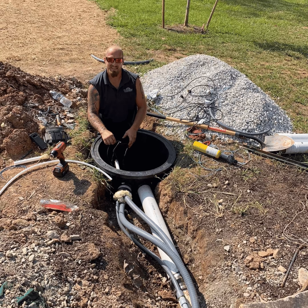 Technician working at an open outdoor drain access