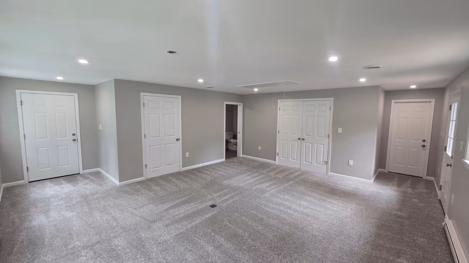 Finished basement with new flooring, walls, and doors