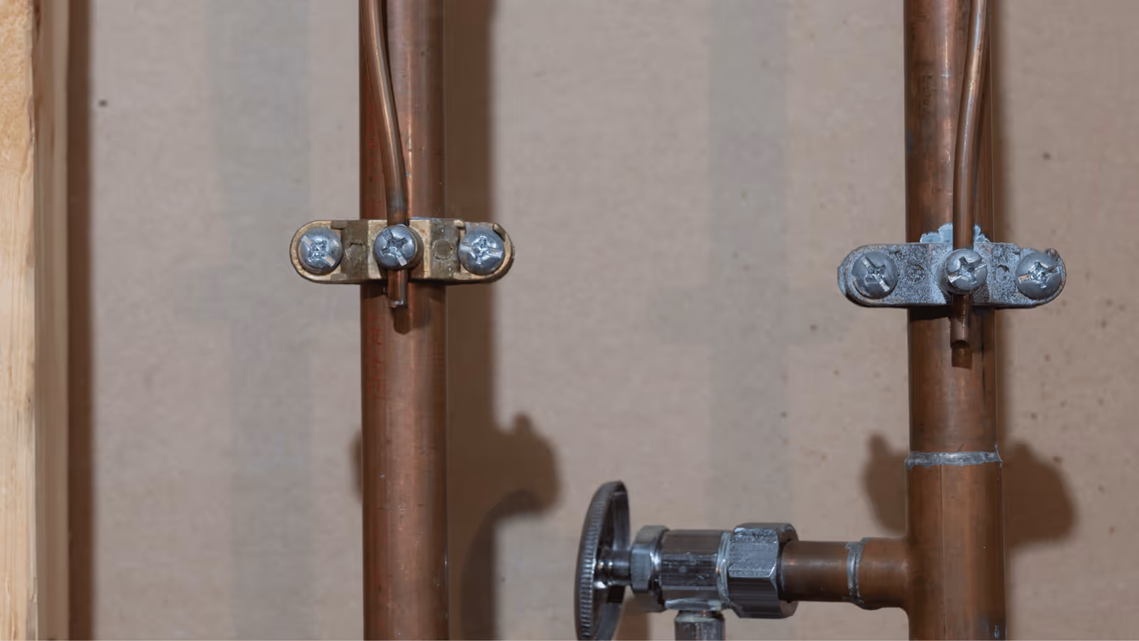 Copper water lines and a shutoff valve along a wall