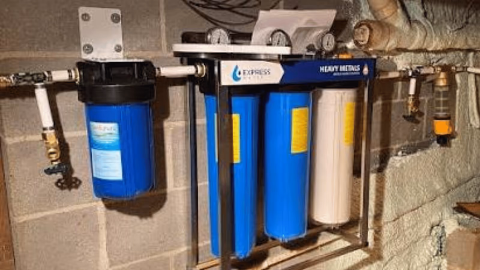 Whole-home water filtration system mounted on a basement wall